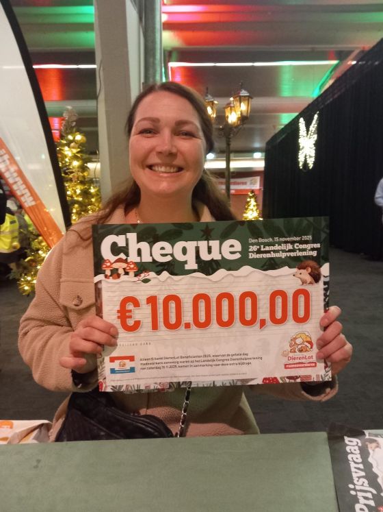 Vrijwilliger Kim met de ontvangen DierenLotcheque tijdens het congres
