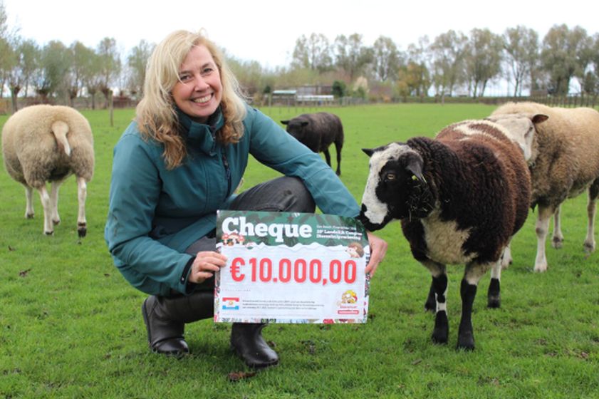 Medwerker Chantal laat schaap Willow de cheque van dichterbij bekijken ;-)